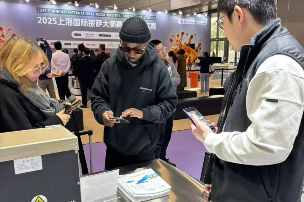 Overseas buyers reviewing KAISON ice machine specifications at Booth 7E31